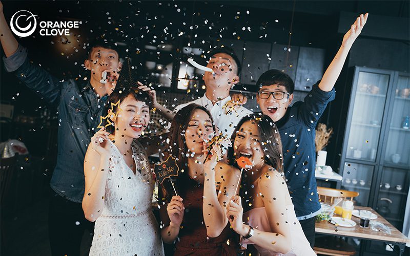 Group of Young Asian Holding Props and Celebrating with Confetti
